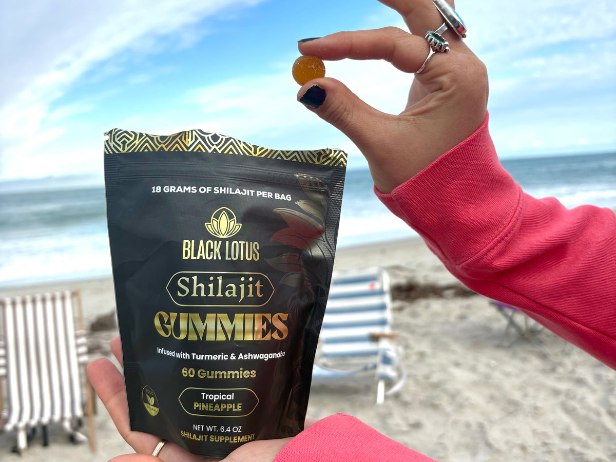 Holding a Black Lotus Shilajit gummy at the beach